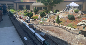 Railroad moving through a miniature garden railroad