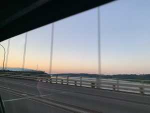 View of a sunset over a bridge from a car window