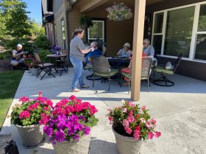 A group of seniors enjoying drinks and food on a patio while being filmed for a video shoot.