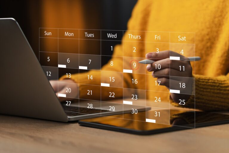 A person holding a tablet pen while working on their laptop and tablet, with a digital overlay hovering in front of them