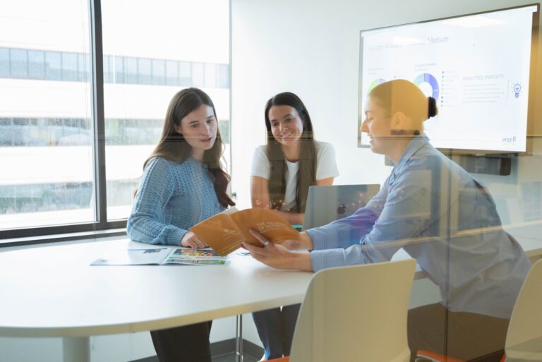 group of client service representatives gather in a meeting room to discuss strategy